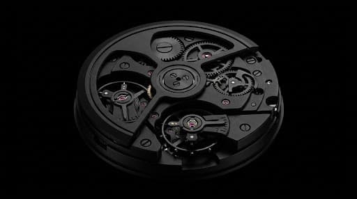 Luxury watch movement in deep monochrome lighting.
